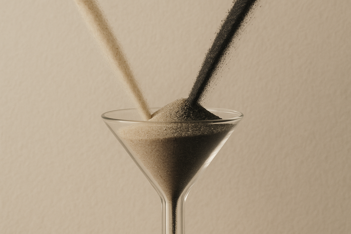 Two streams of pale and dark grains crowding into the narrow neck of a single glass funnel