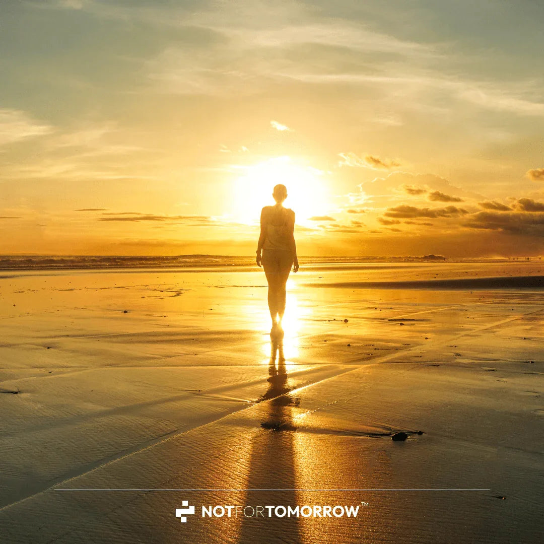 Person walking on beach at sunrise, golden reflection, healthy lifestyle inspiration