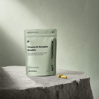 NOTFORTOMORROW Vitamin B-Komplex Bioaktiv pouch on a stone podium with two cream capsules in front